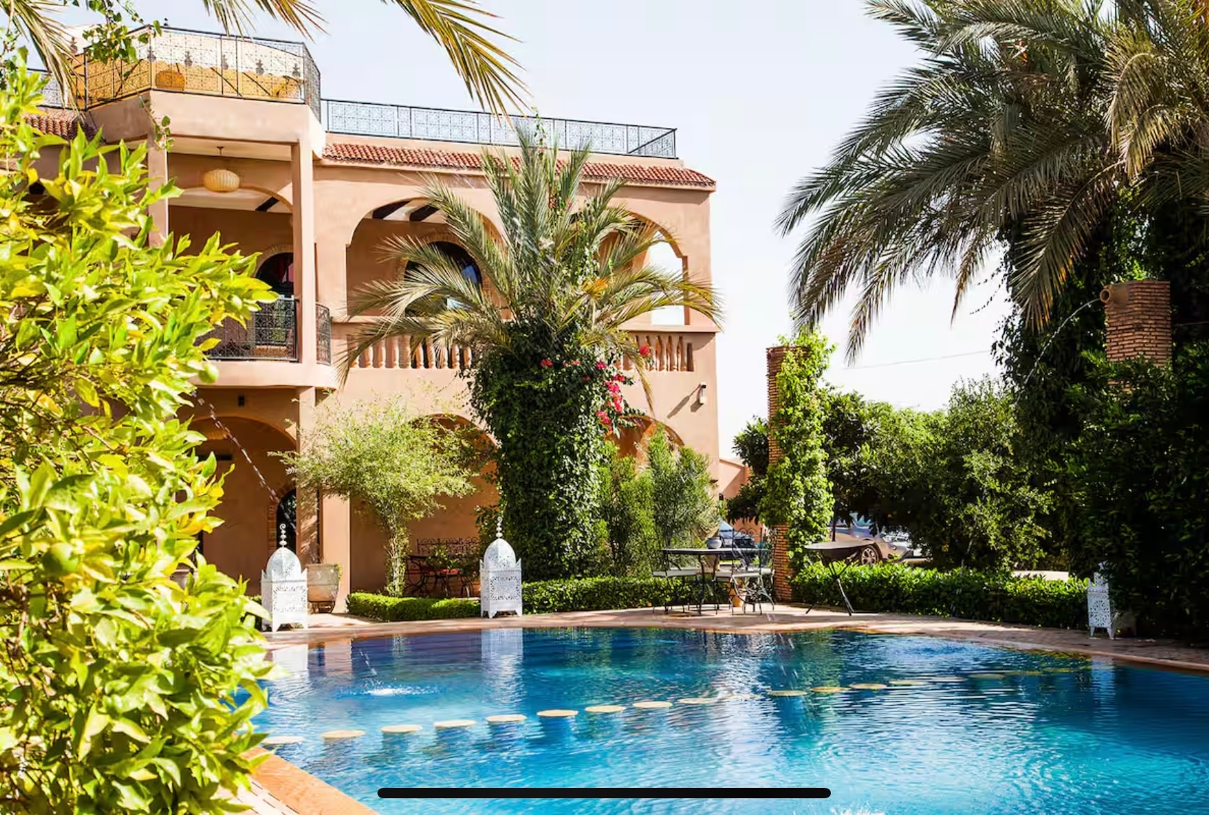 Riad villa exterior with pool and palm trees