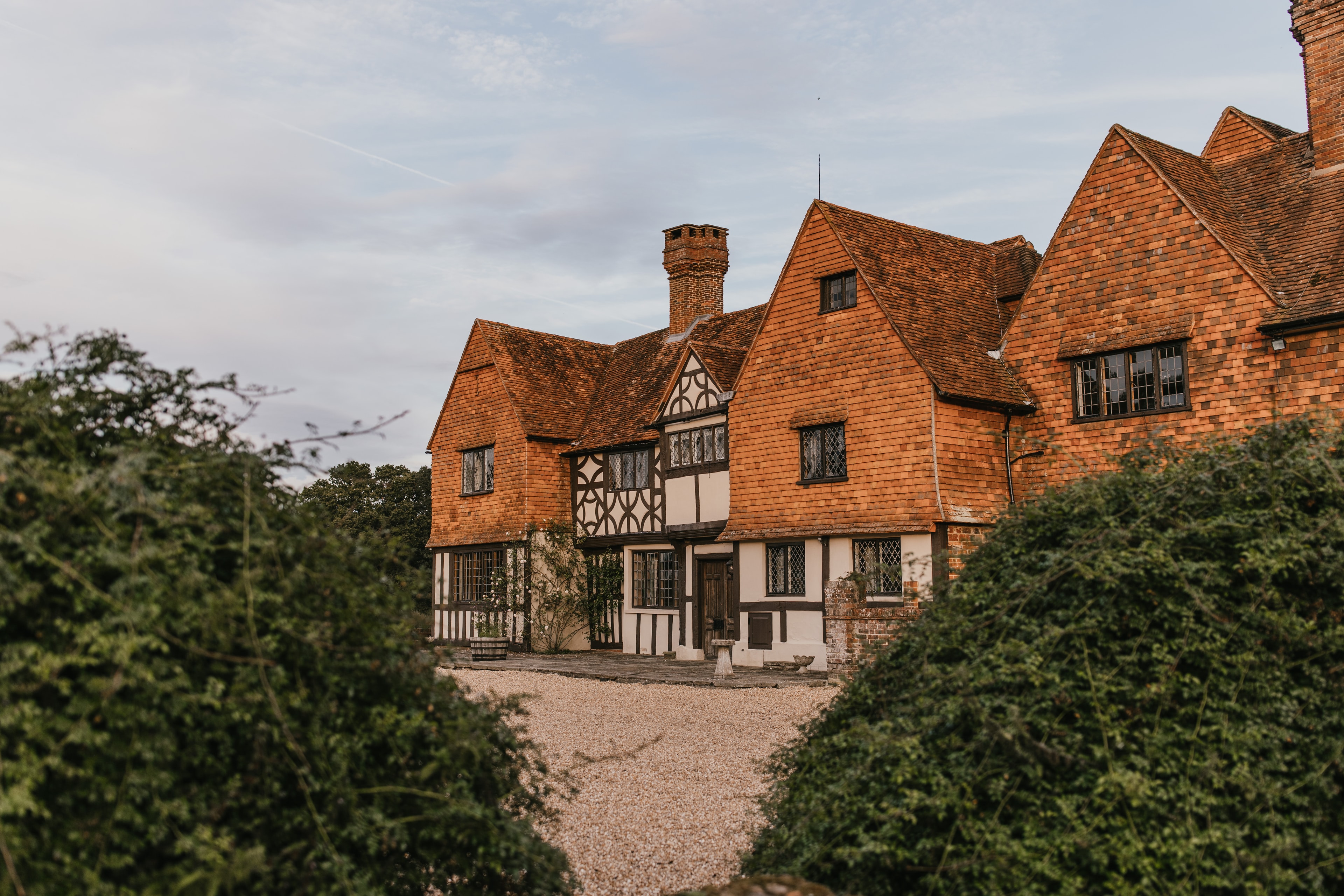 Burningfold Manor exterior framed by gardens at dusk