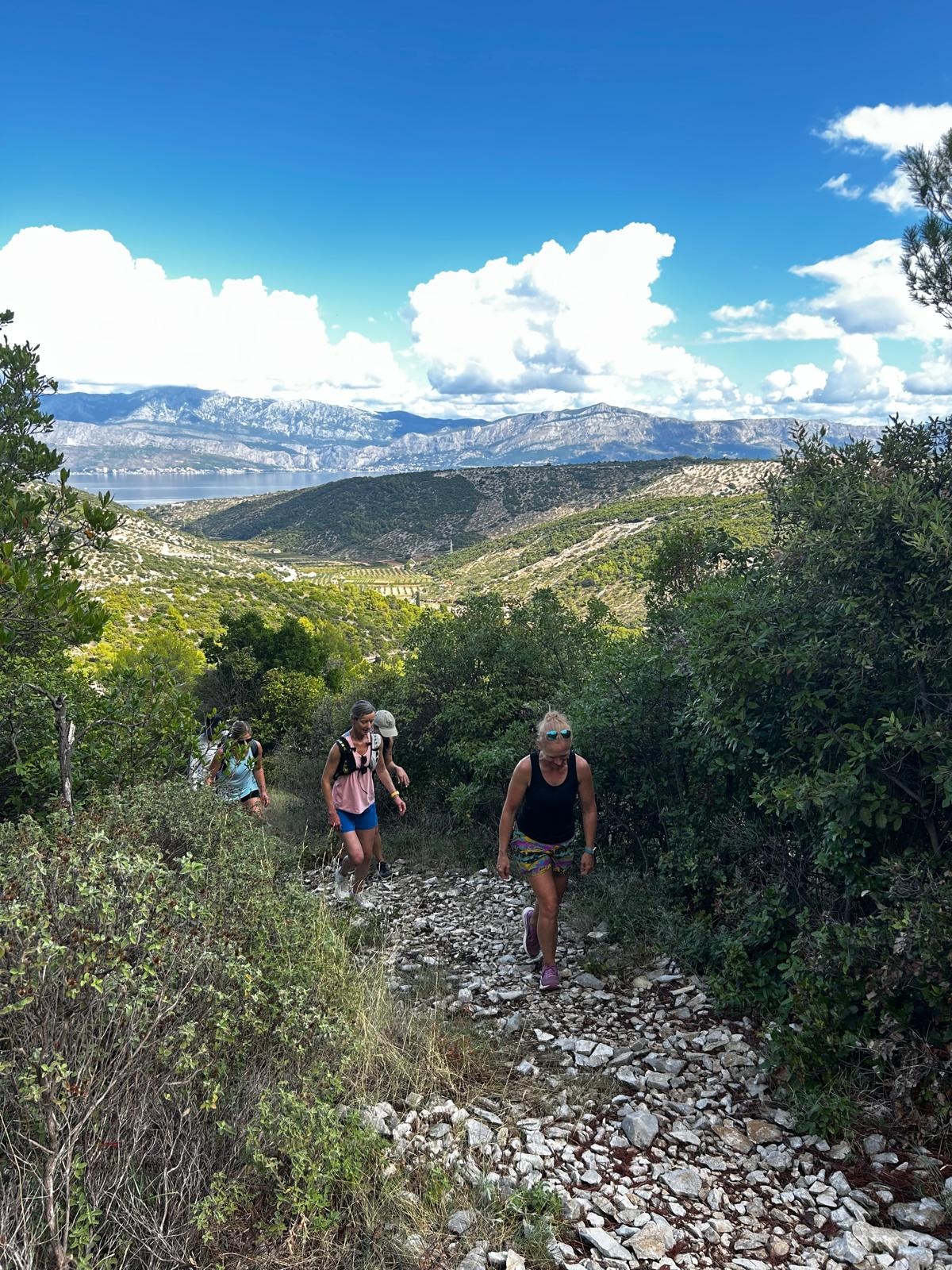 Group hiking a rocky trail with Adriatic views